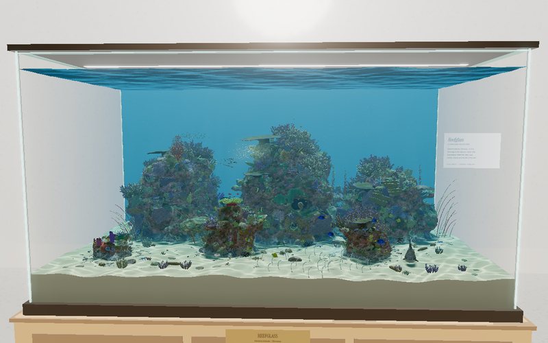 Reefglass in case view: three coral heads in clear turquoise water inside a glass tank on a wooden stand, with rippling light on the white sand.